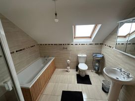 A bathroom with bathtub, toilet, and sink at Storey and Half House Near Annagry, County Donegal