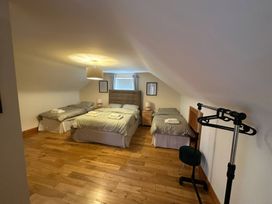 A bedroom with three beds and a clothes rack at Storey and Half House near Annagry, County Donegal