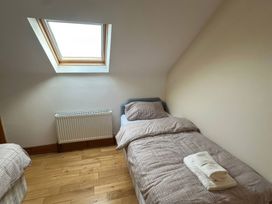 A bedroom with beds and a window at Storey and Half House near Annagry, County Donegal