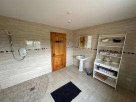 A bathroom with a shower and washbasin at Storey and Half House Near Annagry, County Donegal