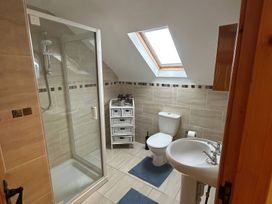 A bathroom with a shower, toilet, and sink at Storey and Half House Near Annagry, County Donegal