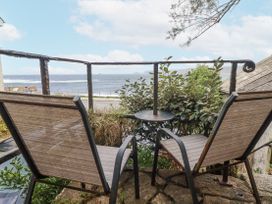 An outdoor space with chairs and table overlooking the ocean at Cove Retreat in Penzance