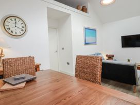 A living room with a wooden table and chairs at Cove Retreat in Penzance