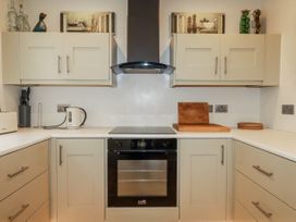 A kitchen with cabinets and cooker at Cove Retreat in Penzance