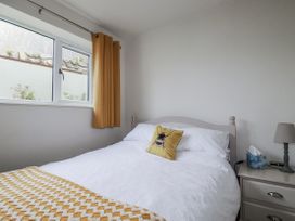 A bedroom with a bed and nightstand at Cove Retreat in Penzance