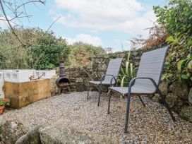 A garden with chairs and a chimenea at Cove Retreat in Penzance