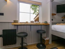 A kitchen with bar stools and counter at Little Hut in Grange-Over-Sands