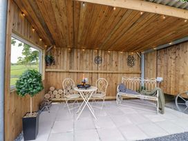 An outdoor seating area with a table and chairs at Little Hut in Grange-Over-Sands