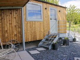A wooden structure with a door and staircase at Little Hut Grange-Over-Sands
