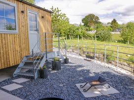 An outdoor area with steps leading to a door and a fire pit at Little Hut Grange-Over-Sands