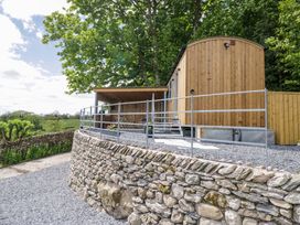 A wooden cabin with gravel and stone wall at Little Hut in Grange-Over-Sands