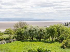 A view of trees and grass with a river in the background at Little Hut in Grange-Over-Sands