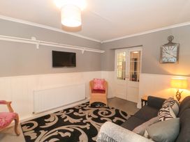 A living room with a sofa and television at Stones Bakery in Wedmore
