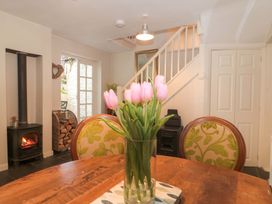A dining room with a table and flowers at Stones Bakery in Wedmore