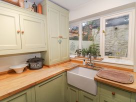 A kitchen with sink and storage cabinets at Stones Bakery in Wedmore