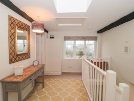 A hallway with a console table and window at Stones Bakery in Wedmore