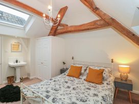 A bedroom with a bed and washbasin at Stones Bakery in Wedmore