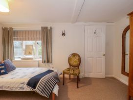A bedroom with a bed and a chair at Stones Bakery in Wedmore