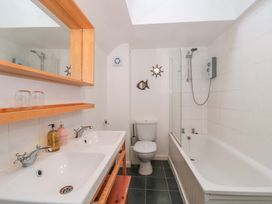A bathroom with a bath tub, toilet and sink at Stones Bakery in Wedmore