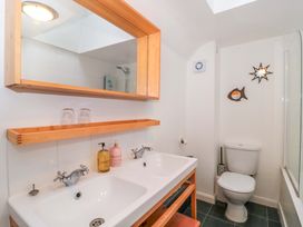 A bathroom with a wash basin and mirror at Stones Bakery in Wedmore