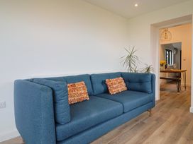 A living room with a blue sofa and a table in Little Poppes Lawn in Holditch near Hawkchurch