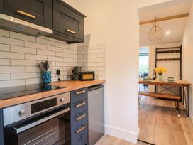 A kitchen with appliances and dining area at Little Poppes Lawn in Holditch near Hawkchurch