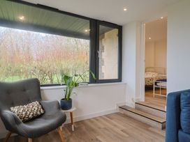 A seating area with a chair and plant at Little Poppes Lawn in Holditch near Hawkchurch