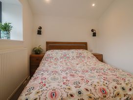 A bedroom with a bed and bedside table at Little Poppes Lawn in Holditch near Hawkchurch