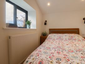 A bedroom with a bed and window at Little Poppes Lawn in Holditch near Hawkchurch