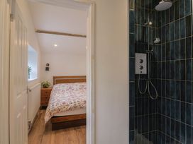 A bathroom with a shower and an adjoining bedroom at Little Poppes Lawn in Holditch near Hawkchurch