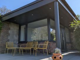 An outdoor seating area with chairs and a potted plant at Little Poppes Lawn, Holditch near Hawkchurch