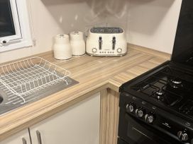 A kitchen with a sink, toaster, drying rack at 169 Abergele