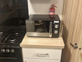A kitchen with a microwave and gas stove at 169 Abergele