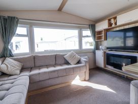 A living room with a sofa and television at St Michaels Caravan Park - 236 Towyn