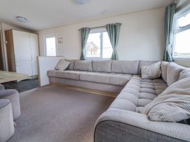 A living room with a sofa and table at St Michaels Caravan Park - 236 Towyn
