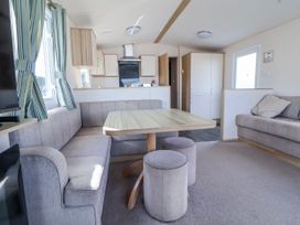 A living room with a dining table and sofa at St Michaels Caravan Park - 236 Towyn