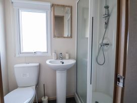 A bathroom featuring a toilet, sink, shower, and window at St Michaels Caravan Park - 236 Towyn
