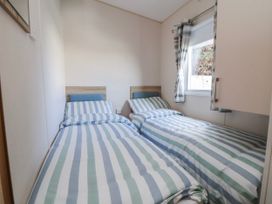 A bedroom with two beds and a window at St Michaels Caravan Park - 236 Towyn