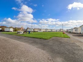 A park area with caravans and grass at St Michaels Caravan Park - 236 Towyn