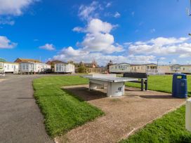 An outdoor area with a ping pong table and static caravans at St Michaels Caravan Park - 236 Towyn