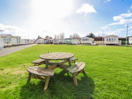 A picnic table in an outdoor area with caravans at St Michaels Caravan Park - 236 Towyn