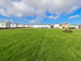 An outdoor area with grass and caravans at St Michaels Caravan Park - 236 Towyn
