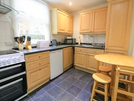 A kitchen with wooden cabinets and appliances at Smugglers Cove in Dartmouth