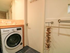 A laundry room with a washing machine and countertop at Smugglers Cove Dartmouth