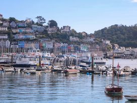 A marina with boats and houses at Smugglers Cove in Dartmouth