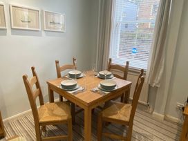 A dining room with a table and chairs at Snugglers Cove in Dartmouth