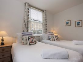 A bedroom with two beds and window at Snugglers Cove in Dartmouth