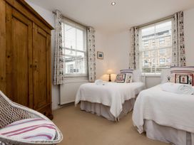 A bedroom with two beds and a wardrobe at Snugglers Cove in Dartmouth