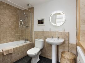A bathroom with a bathtub, toilet, and sink at Snugglers Cove Dartmouth