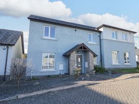 A house with a stone front door and landscaped driveway at 27 Oversands View